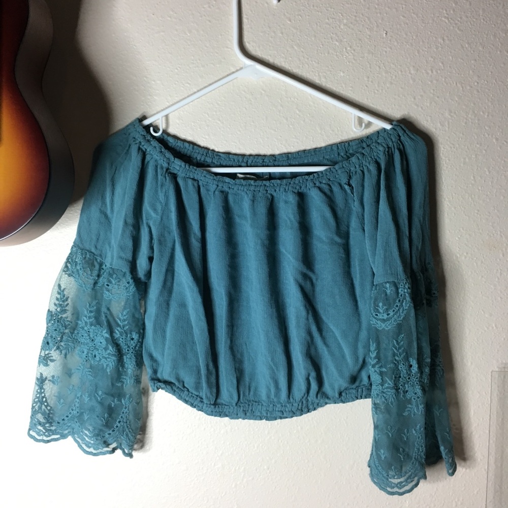 Turquoise off the shoulder top with sheer sleeves.